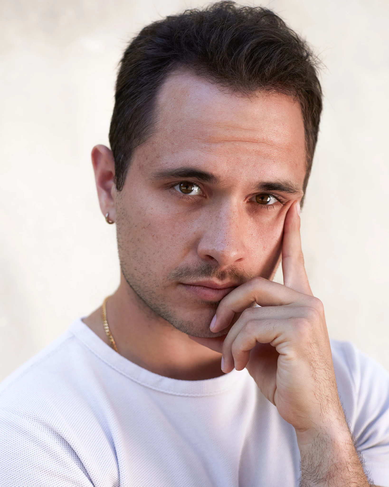 Simon Rajala — close-up portrait in a white shirt, hand against cheek