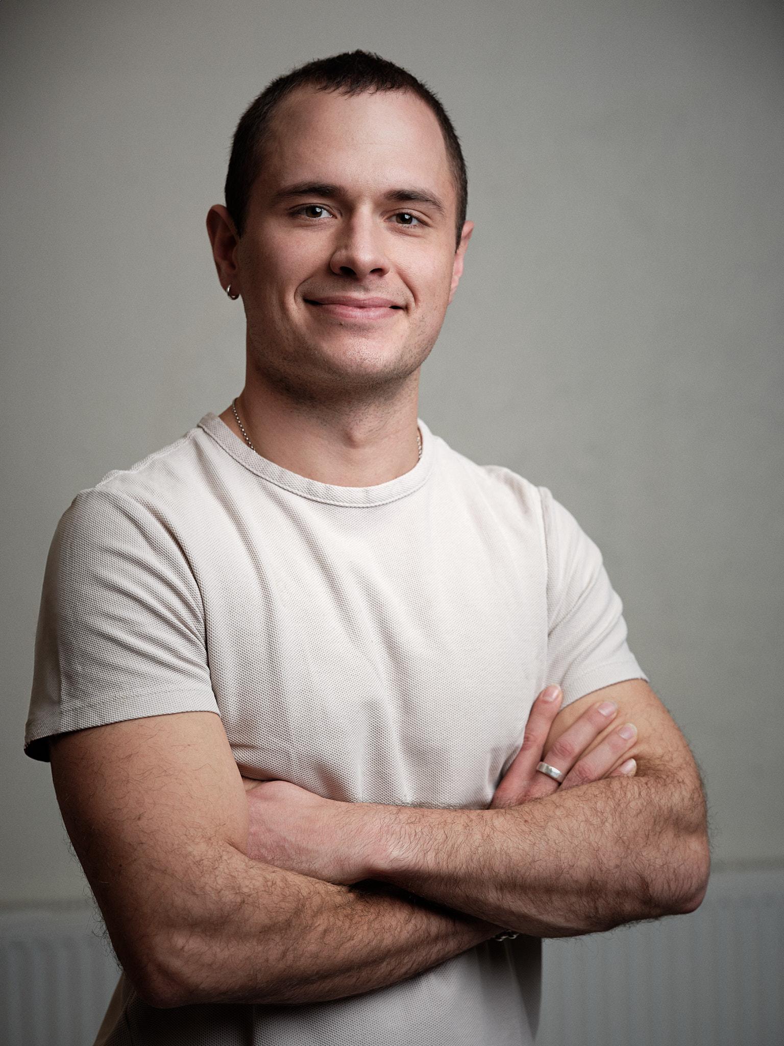 Simon Rajala — professional portrait in a light shirt, arms crossed