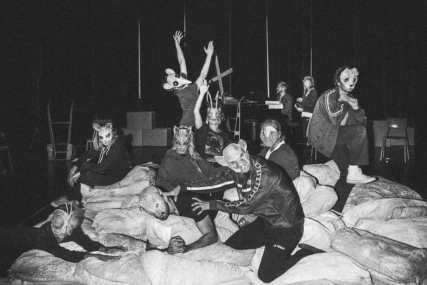 actors with masks in a dark room